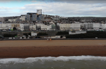 Sweeping shot of East Brighton and the beach, camera over the sea facing north