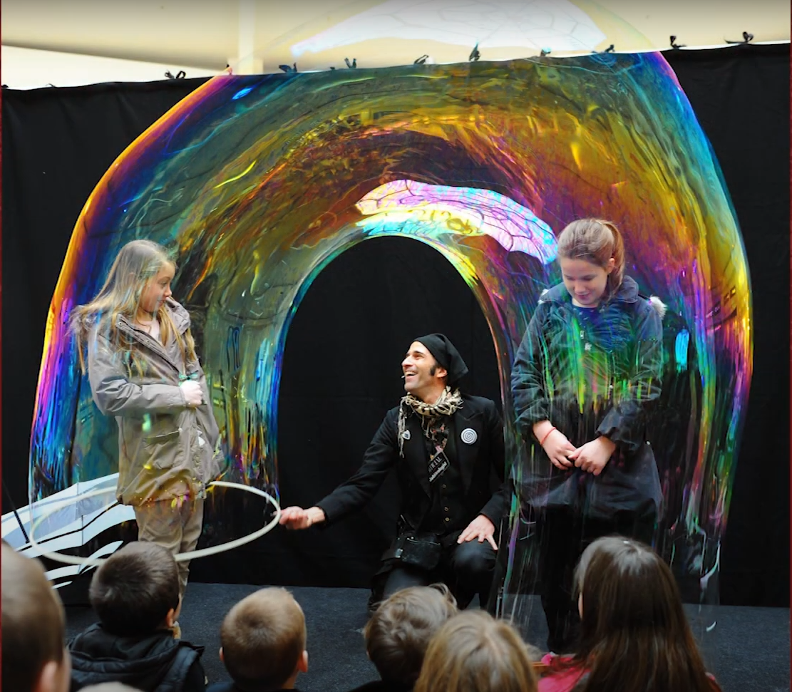 Sam Sam the Bubbleman pulling a bubble over a child