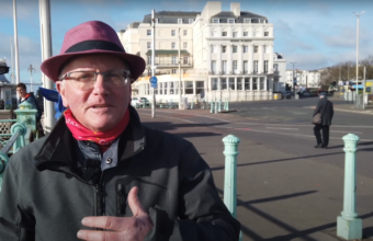 Local Musician Tim Izzard talks to the camera on brighton seafront